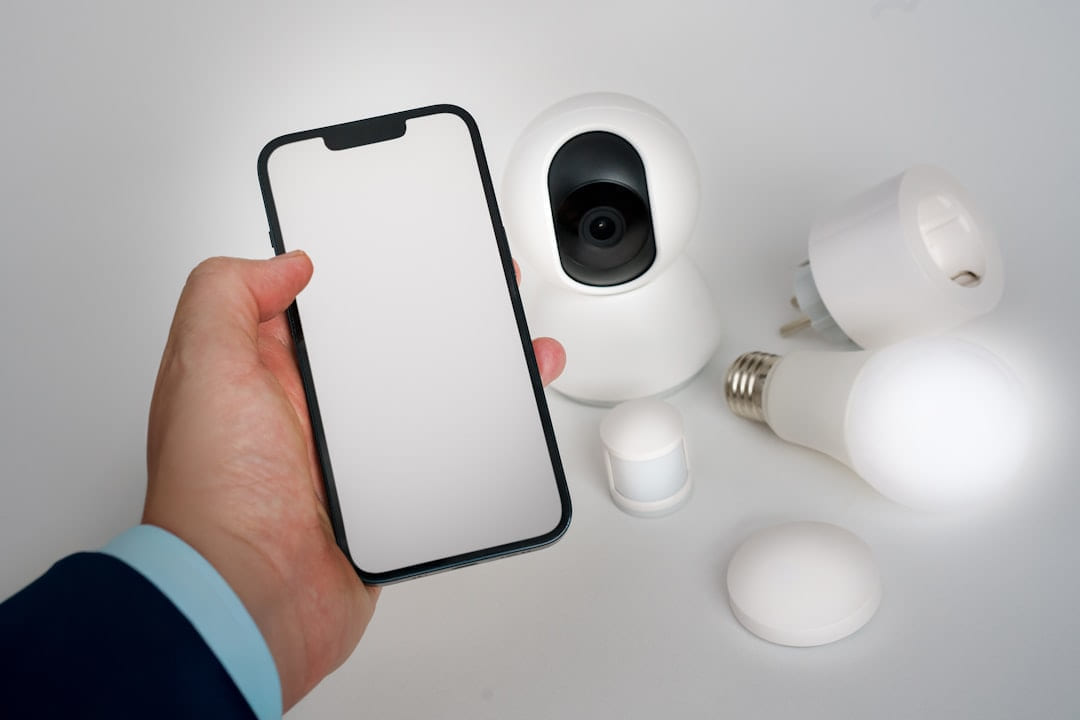 A person holding a smart phone next to a camera on Affordable Smart Living