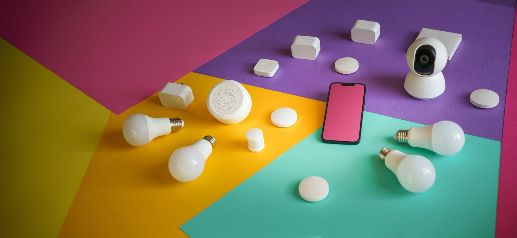 A vibrant display of smart home devices including bulbs, sensors, and a smartphone on a colorful background. on Affordable Smart Living