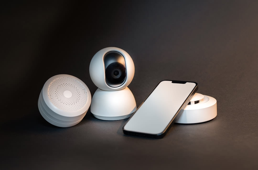a smart phone sitting next to a wireless security camera on Affordable Smart Living